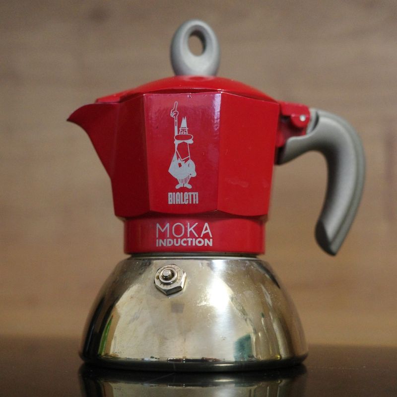 Na obrázku je Bialetti Moka Induction na varné desce. Konvička je v červené barvě.